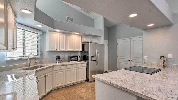 A modern kitchen with white cabinets, a stainless steel refrigerator, and a granite countertop. - Private Patio + Pool Access: Quiet Condo in Tempe (Tempe)