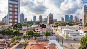 A cityscape with high-rise buildings, a mix of residential and commercial structures, and a clear sky. - Apê no melhor de LagoaNova Por Carpediem (Natal)