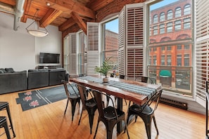A dining area with a wooden table, chairs, and a potted plant.