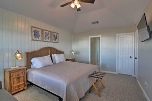 A bedroom with a bed, wooden nightstands, a ceiling fan, and framed artwork on the wall. - Terramar Beach & Pool Access: West Galveston Home! (Galveston)