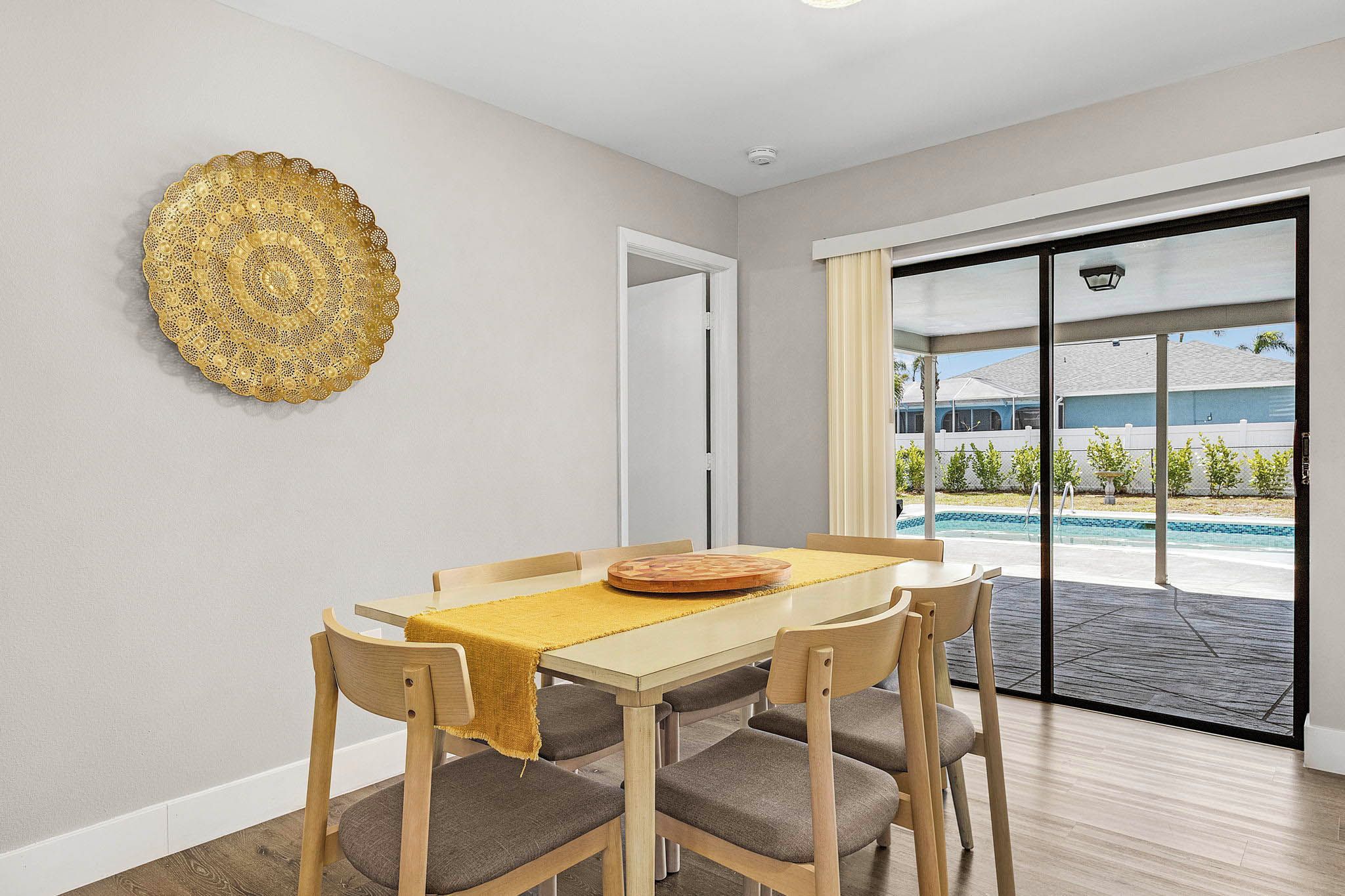 A dining area with a table, chairs, and a decorative wall piece.