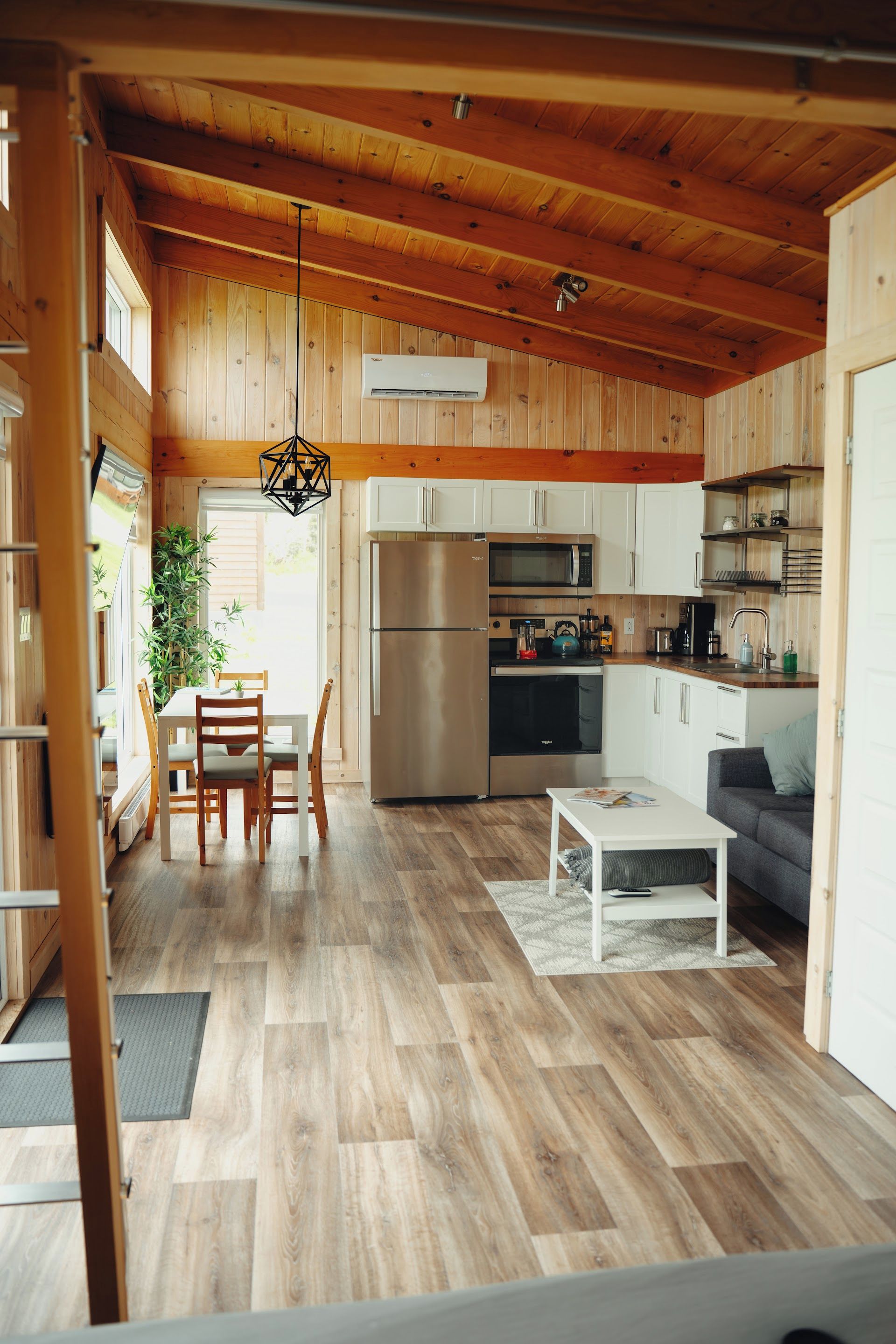 Una cocina moderna con armarios de madera, un refrigerador de acero inoxidable y un microondas.