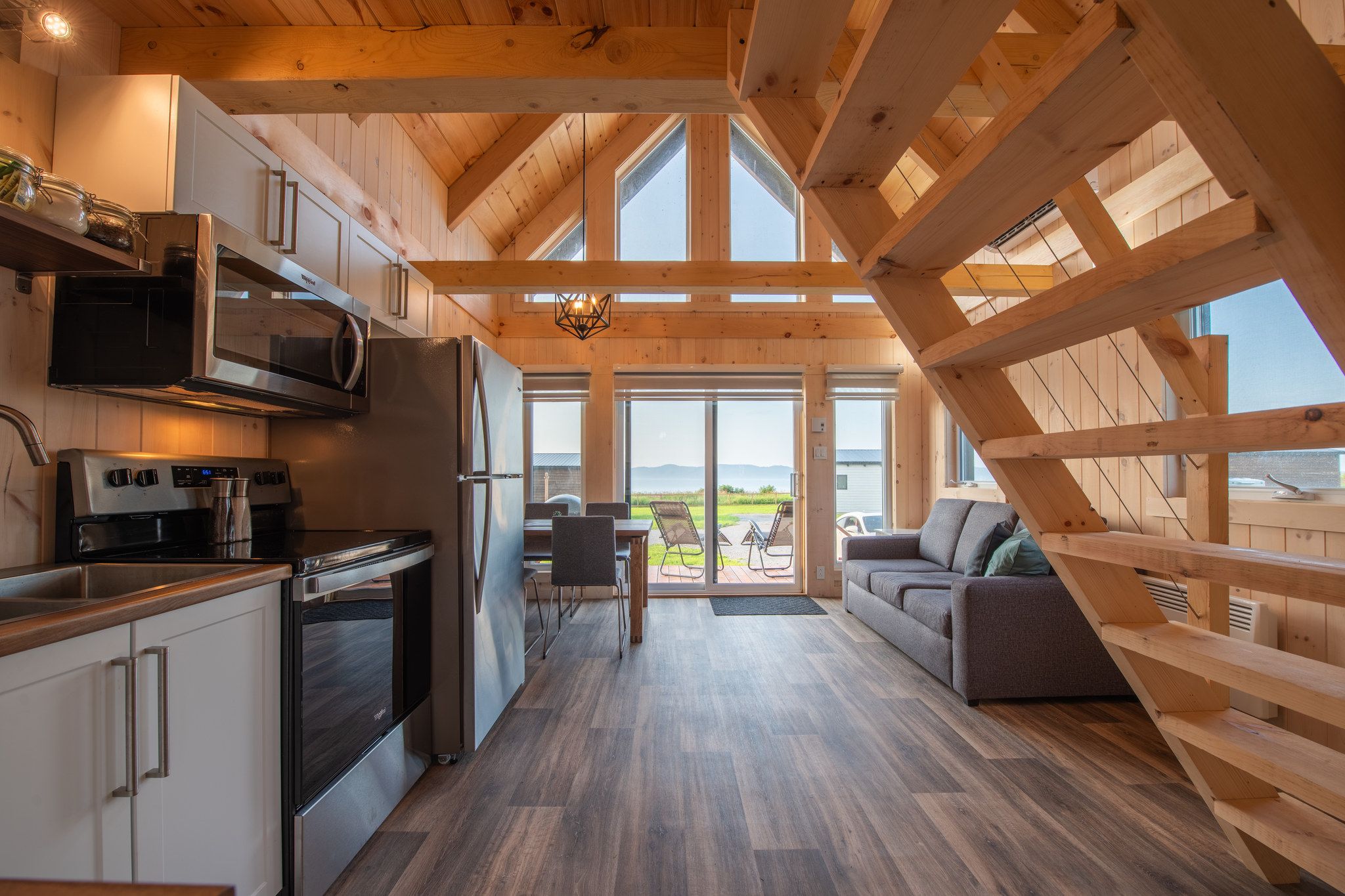 A modern kitchen with stainless steel appliances, a dining area with a view, and a cozy seating area.