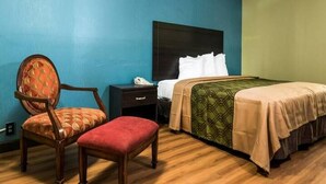 A hotel room with a bed, a chair, a nightstand, and a telephone. - King Bed Efficiency Non-Smoking at Royal Extended Stay Hotel Selma I-95 (Selma)