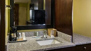 A bathroom with a granite countertop, a coffee maker, a sink, and a mirror. - King Bed Efficiency Non-Smoking at Royal Extended Stay Hotel Selma I-95 (Selma)