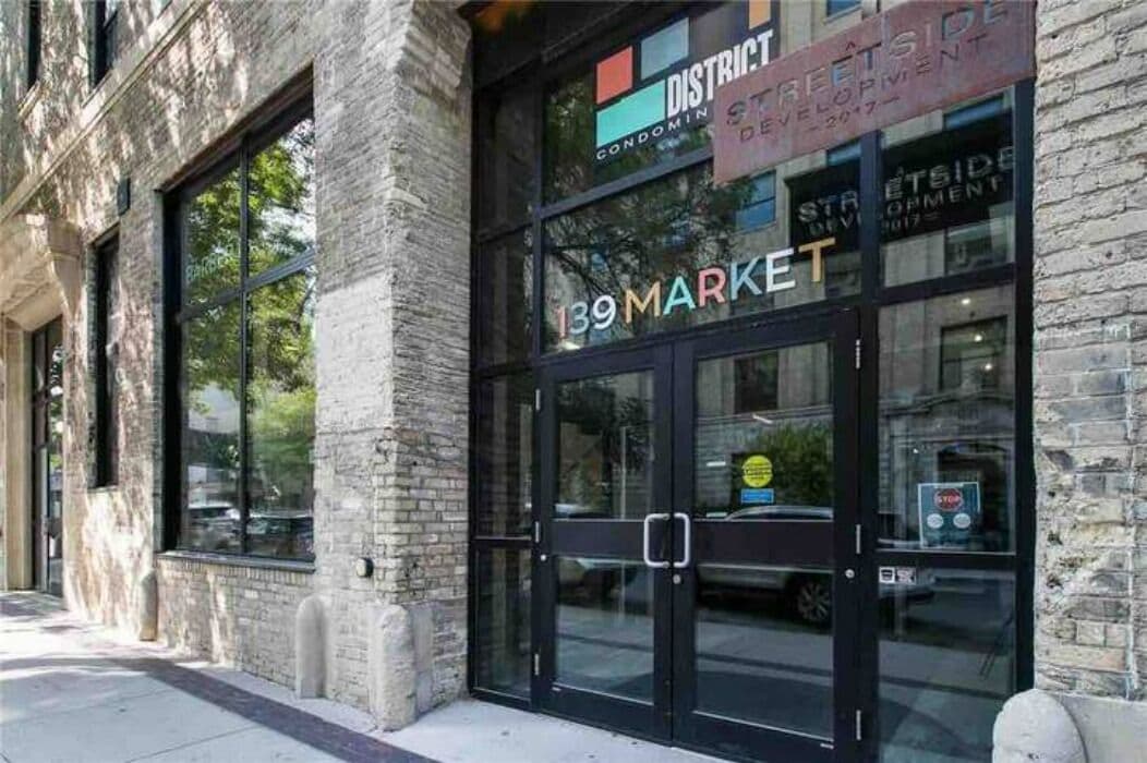 A building with a sign that reads "District Condominium Development 139 Market."
