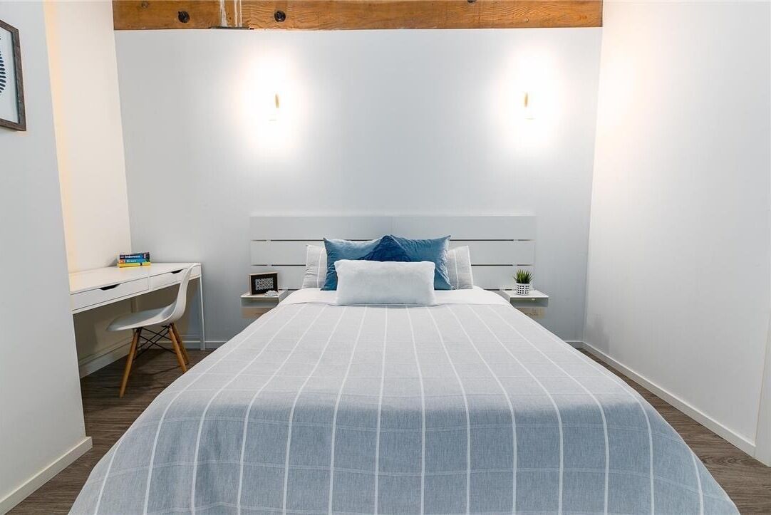 Ein Schlafzimmer mit einem Bett, einem Schreibtisch und einem Stuhl.