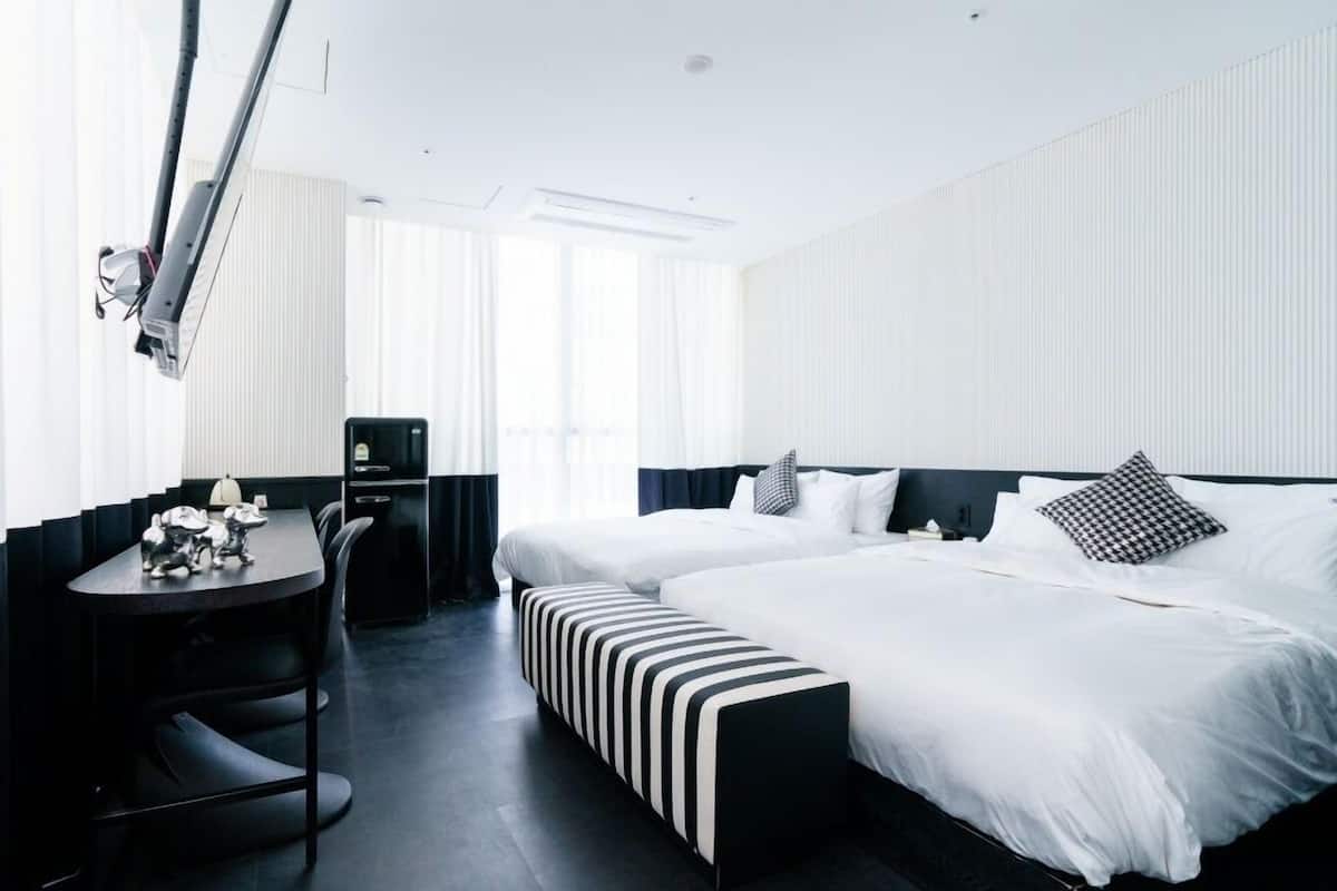 Una habitación de hotel moderna con una cama grande, un escritorio y una silla.
