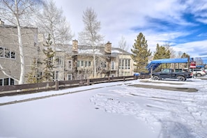 Una calle cubierta de nieve con un edificio que tiene ventanas grandes y una chimenea.