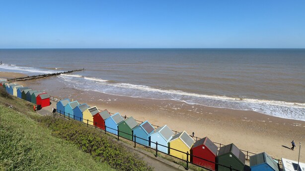 A beach with colorful beach huts and a clear view of the sea. - 31 Seaward Crest (Norwich)