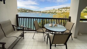 A balcony with a view of the sea, featuring a table and chairs. - VIEWS & MORE VIEWS!  Cowpet Bay East, water front condo, steps from beach.  (St Thomas)