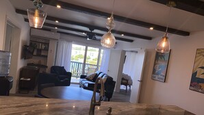 A modern kitchen with a marble countertop, a sink, and pendant lighting. - VIEWS & MORE VIEWS!  Cowpet Bay East, water front condo, steps from beach.  (St Thomas)