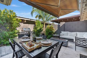 Enjoy a casual meal in an outdoor space with a dining table, barbecue grill, and comfortable seating.