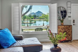 Relax in a serene space with a view of a body of water, a mountain, and a park.