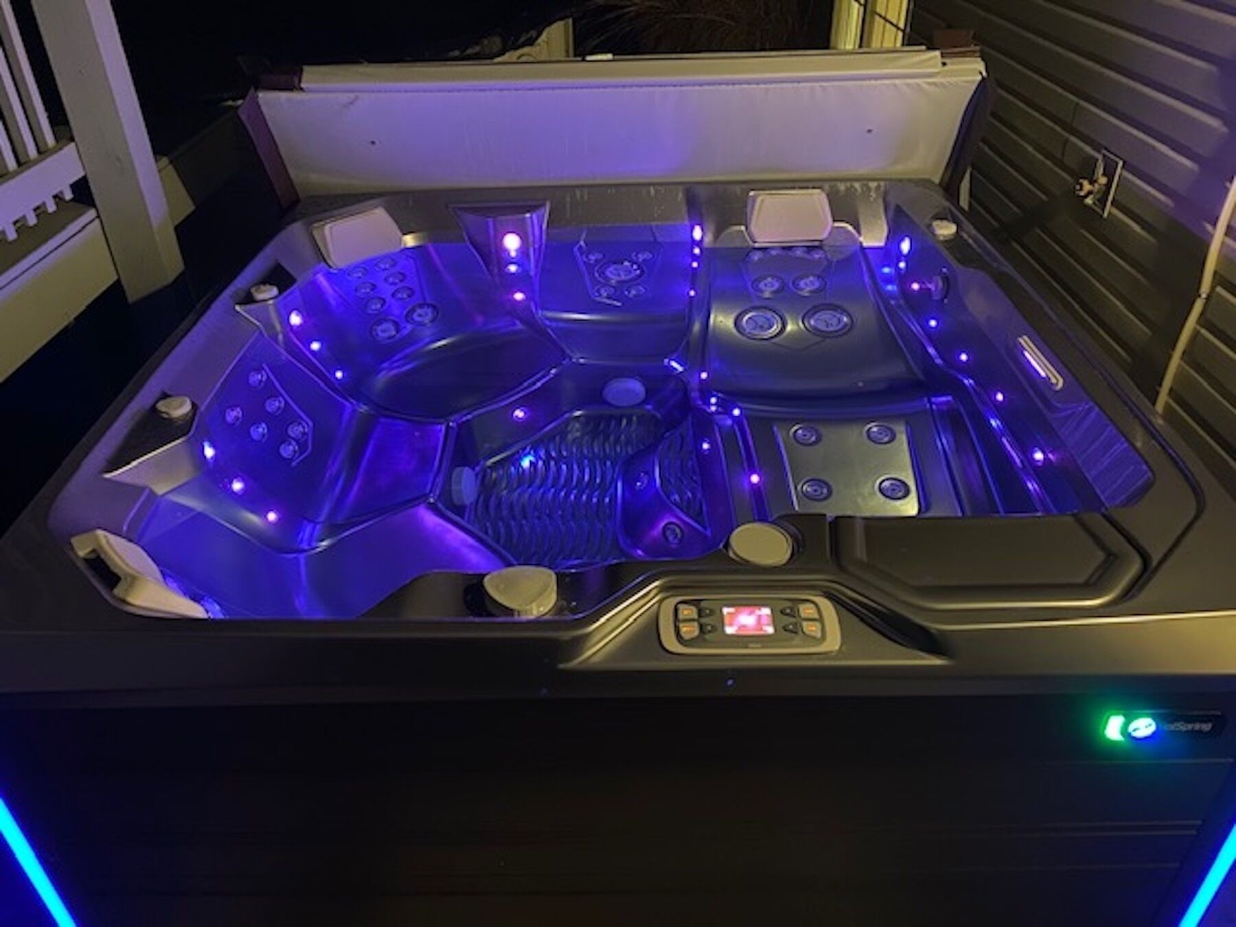 A hot tub with multiple jets and a control panel.