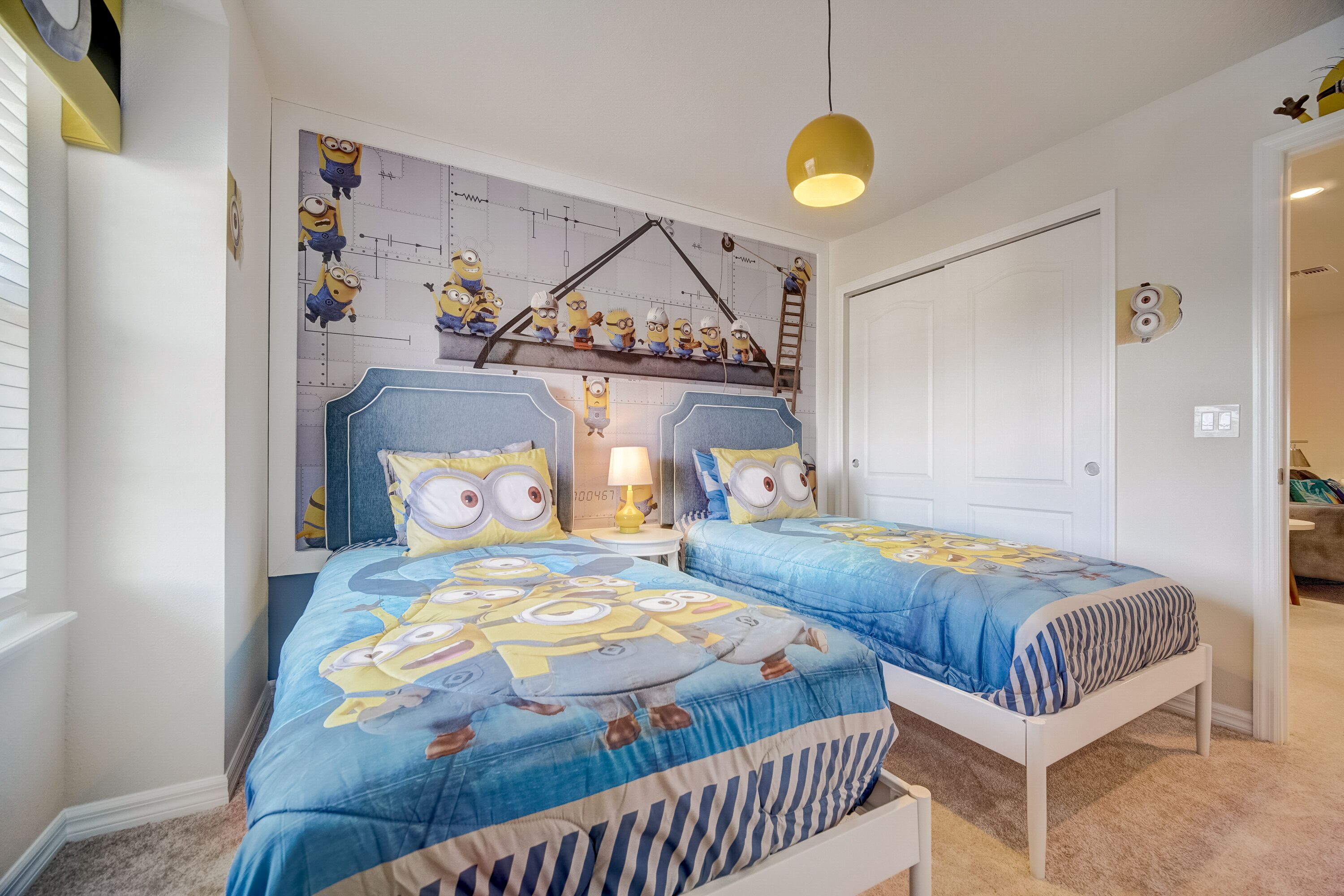 Une chambre avec deux lits, une horloge murale et un luminaire suspendu.