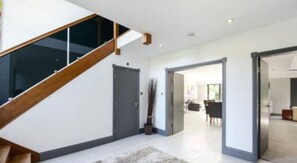 Stunning staircase leads to a spacious communal area with seating.