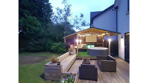 Relax on the patio with a bench and seating area, surrounded by a fence with a view.