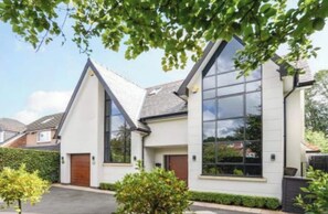 Stylish two-story home with a symmetrical facade and a prominent glass window.