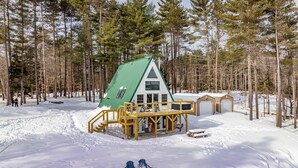 A cabin with a green roof, wooden deck, and a garage. - EPIC VIEWS - Pond - Crooked River 14 ACRES - SECLUDED (Harrison)