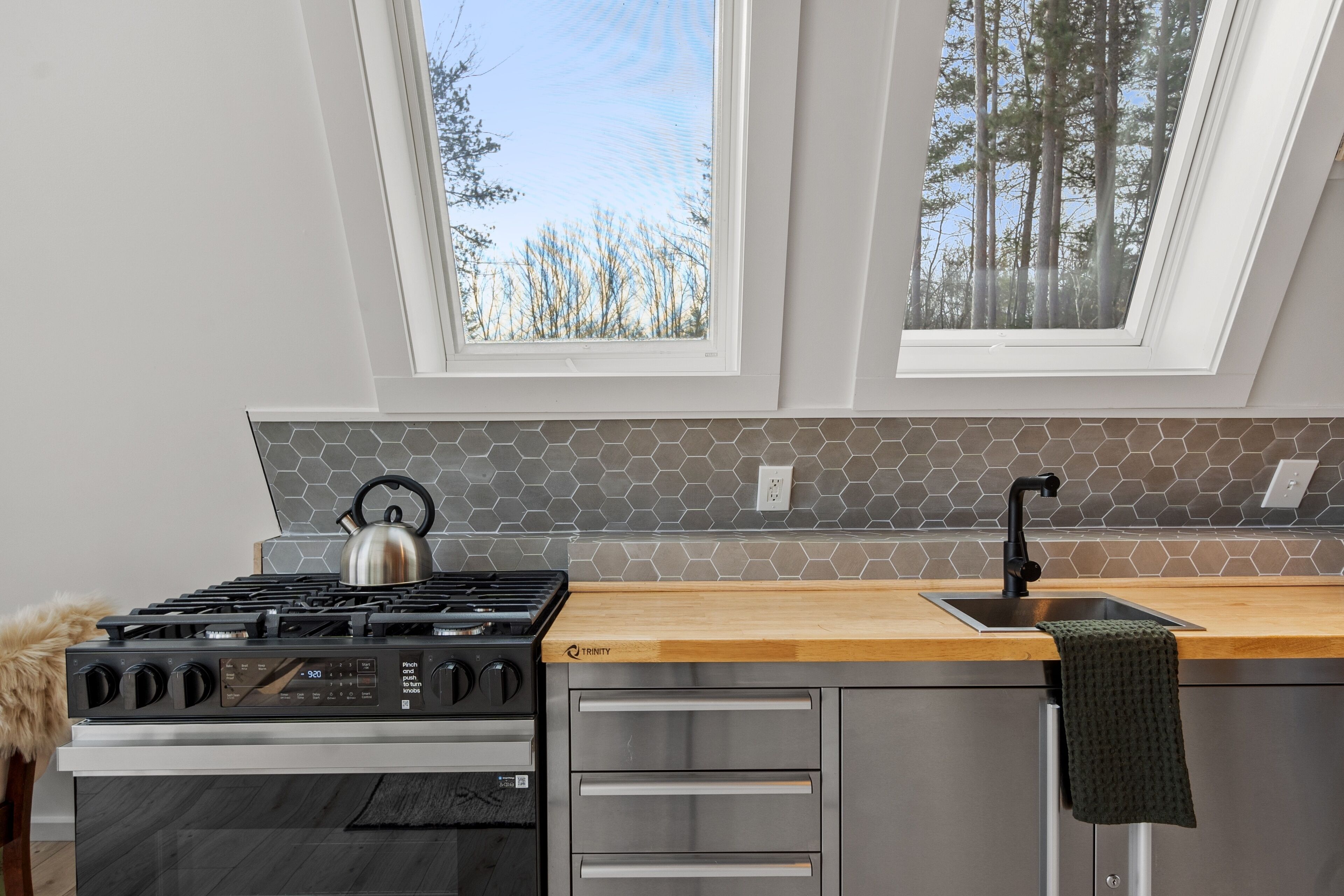 Eine moderne Küche mit Gasherd, Backofen und einer Holzauskleidung.