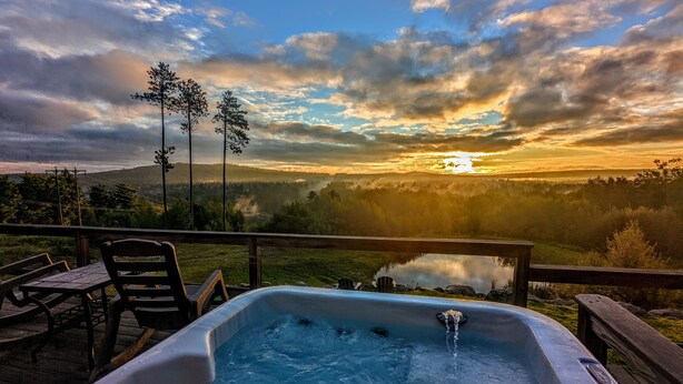 A hot tub on a deck with a view of a sunset over a valley. - EPIC VIEWS - Pond - Crooked River 14 ACRES - SECLUDED (Harrison)