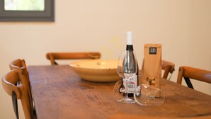 Une table en bois sur laquelle se trouvent une bouteille de vin, un verre à vin et un tire-bouchon.