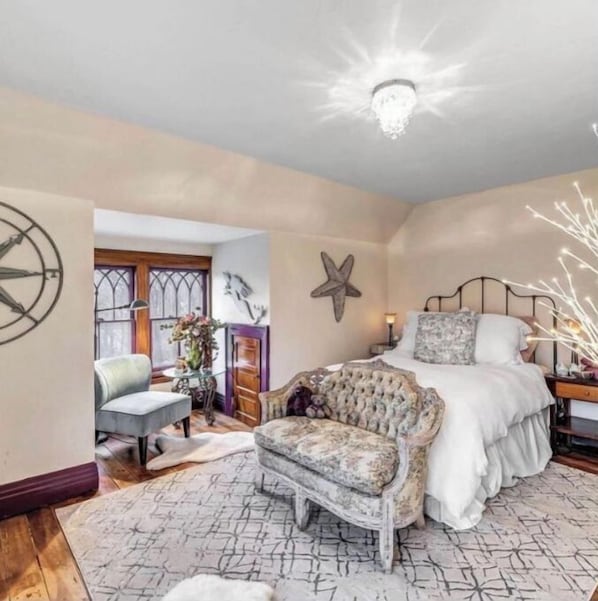 A bedroom with a bed, a chair, a decorative wall, and a starfish decoration.