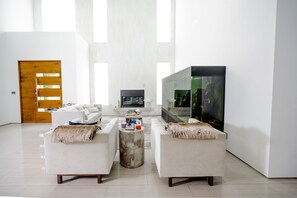 Relax in this stylish living room with a large TV, comfortable sofas, and a soothing aquarium.