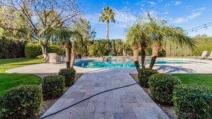 A swimming pool with a paved pathway leading to it, surrounded by palm trees and well-maintained hedges. - Resort Backyard w/Private Pool- Spacious Home close to Stadium & Spring Training (Glendale)