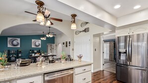 A modern kitchen with a granite countertop, stainless steel appliances, and a ceiling fan. - Resort Backyard w/Private Pool- Spacious Home close to Stadium & Spring Training (Glendale)
