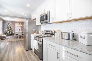 A modern kitchen with white cabinets, stainless steel appliances, and a countertop with a bread maker. - The search is over! Perfectly located between the Ark & the Creation Museum! (Walton)