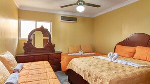 A hotel room with two beds, a large mirror, and a ceiling fan. - Santo Domingo Este Retreat With 2 Bedrooms Apt (Santo Domingo Este)