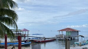 Eine hölzerne Pier mit einem kleinen Pavillon, einem roten und einem blauen Boot, die dort festgemacht haben.