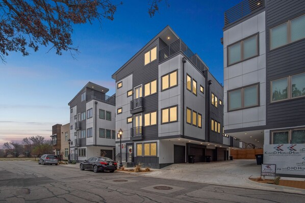 A multi-story residential building with a modern design, featuring balconies and large windows.