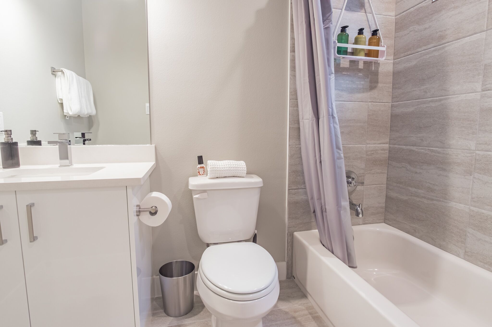 A modern bathroom with a toilet, sink, and bathtub.
