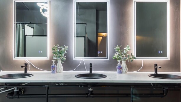 A modern bathroom with three sinks, each with a mirror above. There are plants on the counter, and visible plumbing and lighting fixtures. - McKinley Mansion Full Building w/Bball gym, Arcades, 13000 sqft, Sleeps 70.  (Pocatello)