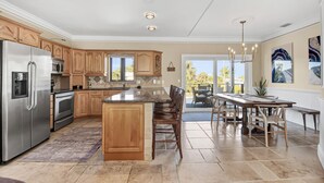 A modern kitchen with wooden cabinets, stainless steel appliances, and a large island. - Winter Getaway by the Bay. Direct Water View! Near Marco Island Beaches. (Naples)