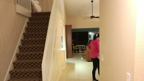 A staircase with patterned carpet leading to a room with a ceiling fan. - Westgate Vacation Villas Resort (Kissimmee)