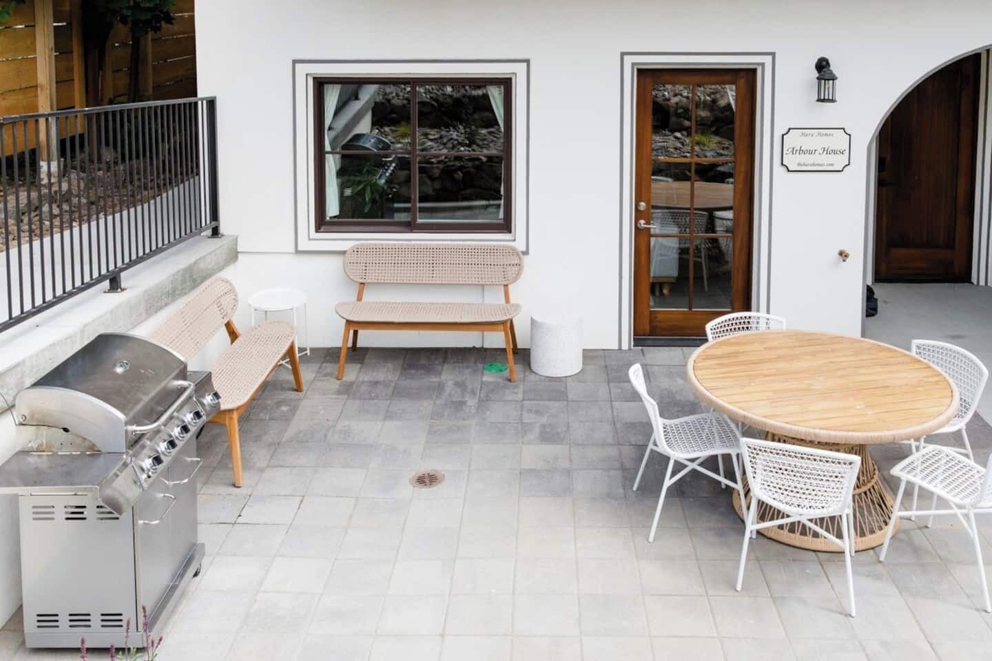 Une terrasse avec un barbecue, des sièges et une table.