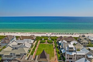 A coastal residential area with houses, a beach, and a clear view of the ocean.