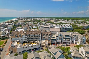 A coastal town with a mix of traditional and modern buildings, a marina, and a beach in the background.