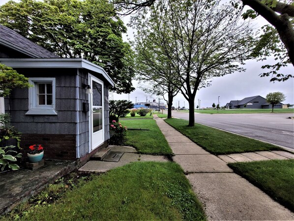A residential house with a front yard, a sidewalk, and a street.