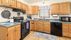 A kitchen with wooden cabinets, a stove, oven, dishwasher, and a microwave. -  ⚓️Close to Duluth! Close to Lake Superior! Whole house! Centrally located! ⚓️ (Superior)