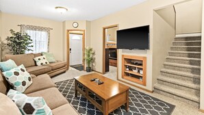 A living room with a sofa, coffee table, TV, and a staircase. -  ⚓️Close to Duluth! Close to Lake Superior! Whole house! Centrally located! ⚓️ (Superior)