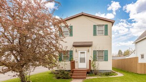 A two-story house with a front porch, a small garden, and a wooden fence. -  ⚓️Close to Duluth! Close to Lake Superior! Whole house! Centrally located! ⚓️ (Superior)