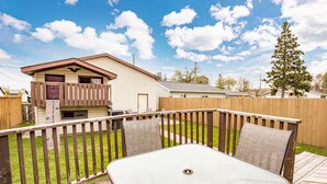 A backyard with a wooden deck, a table with chairs, and a house in the background. -  ⚓️Close to Duluth! Close to Lake Superior! Whole house! Centrally located! ⚓️ (Superior)