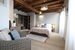 A bedroom with a bed, bedside tables, a wardrobe, and a wicker chair. - Andoitzen Borda - Sare (SARE)