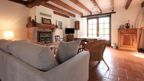 Una sala de estar acogedora con chimenea, asientos cómodos y televisor.