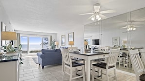 Una cocina moderna con comedor, ventanas amplias y vista al océano.